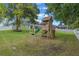 Backyard features a wooden playset with a slide and swings, creating a fun area for children to play at 9512 Mid Summer Ln, Leesburg, FL 34788
