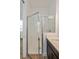 Modern bathroom featuring a glass shower door with white tiles and dark vanity with a quartz countertop at 9674 Rodbell St, Orlando, FL 32827
