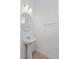 Elegant powder room features a pedestal sink with modern fixtures and a round mirror with stylish lighting at 9674 Rodbell St, Orlando, FL 32827