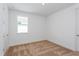 Bright bedroom with neutral carpet, a large window, and a minimalist aesthetic with a door on the right at 9674 Rodbell St, Orlando, FL 32827