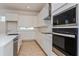 Modern kitchen with stainless steel appliances, white cabinets and quartz countertops at 9674 Rodbell St, Orlando, FL 32827
