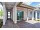 Inviting covered patio with brick pavers, white columns, and sliding glass doors, perfect for outdoor relaxation at 9674 Rodbell St, Orlando, FL 32827