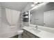 Bathroom featuring a shower and tub with a white shower curtain, toilet, sink, vanity and mirror at 997 Oscar Ln, The Villages, FL 32162