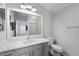 Well-lit bathroom featuring vanity with framed mirror, toilet, and access to shower at 997 Oscar Ln, The Villages, FL 32162