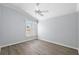 Bright bedroom features a ceiling fan, light blue walls, window with shutter, and hardwood flooring at 997 Oscar Ln, The Villages, FL 32162