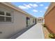 Exterior shot of the home's side yard with a concrete walkway and access to the backyard at 997 Oscar Ln, The Villages, FL 32162