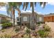 View of the home's desert landscaping, featuring palm trees, rocks, and a garden lamp at 997 Oscar Ln, The Villages, FL 32162