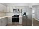 Updated kitchen features stainless steel appliances and shaker style cabinetry at 997 Oscar Ln, The Villages, FL 32162