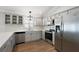 Kitchen features stainless steel appliances, gray cabinets, stone countertops, and decorative backsplash at 997 Oscar Ln, The Villages, FL 32162