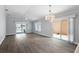 Spacious living room with wood floors, chandelier, and access to outdoor spaces via sliding glass doors at 997 Oscar Ln, The Villages, FL 32162