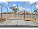 View of the home's spacious screened-in lanai with a concrete patio and white metal frame at 997 Oscar Ln, The Villages, FL 32162