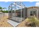 Exterior view of a screened-in lanai featuring a concrete patio and access to the backyard at 997 Oscar Ln, The Villages, FL 32162