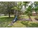 Backyard view featuring play structure, slide, and mature trees at 101 Lakeshore Blvd, St Cloud, FL 34769
