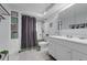Well-lit bathroom featuring a white vanity and a shower with a dark curtain at 101 Lakeshore Blvd, St Cloud, FL 34769
