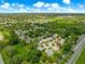 Wide aerial shot showcasing the home's location in a lush neighborhood with nearby amenities and roadways at 1010 Sierra Blanca Ct, Lady Lake, FL 32159
