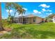 View of backyard with screen enclosed patio with beautiful lawn and landscaping under a bright blue sky at 1010 Sierra Blanca Ct, Lady Lake, FL 32159