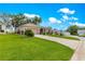 Single-story home featuring a well-manicured lawn, mature trees, and inviting front entrance at 1010 Sierra Blanca Ct, Lady Lake, FL 32159