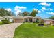 Charming single-story home featuring a well-manicured lawn, mature trees, and inviting front entrance at 1010 Sierra Blanca Ct, Lady Lake, FL 32159