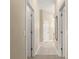 Hallway with neutral paint, carpet and tile flooring, and multiple doors at 1010 Sierra Blanca Ct, Lady Lake, FL 32159