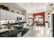 Charming kitchen with white cabinetry, black countertops, island, and adjacent dining area for easy entertaining at 1010 Sierra Blanca Ct, Lady Lake, FL 32159