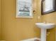 Cozy half bathroom featuring a pedestal sink, modern faucet, and large framed mirror at 107 Wekiva Pointe Cir, Apopka, FL 32712