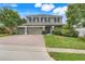 Charming two-story home with a three-car garage and beautiful landscaping, brick driveway, and a well-maintained lawn at 107 Wekiva Pointe Cir, Apopka, FL 32712