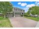 Charming two-story home featuring a brick driveway, well-manicured lawn, and lush landscaping at 107 Wekiva Pointe Cir, Apopka, FL 32712