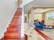 Inviting foyer with wooden staircase leading to the upper level and views into the dining area at 107 Wekiva Pointe Cir, Apopka, FL 32712