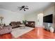 A cozy living room featuring a ceiling fan, rich hardwood floors, and comfortable leather seating at 107 Wekiva Pointe Cir, Apopka, FL 32712