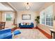 Stylish living room with a modern blue sofa, wooden floors, and plenty of natural light at 107 Wekiva Pointe Cir, Apopka, FL 32712
