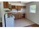 Functional kitchen with vintage wood cabinets, white appliances, and ample counter space at 1109 Willow Ct, Tavares, FL 32778