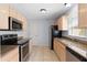 Updated kitchen features granite countertops, stainless steel appliances, and light wood cabinetry at 1116 San Bernardo Rd, The Villages, FL 32162