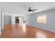 Open-concept living room showing hardwood floors, ceiling fan, sliding doors, and an eat-in kitchen at 1116 San Bernardo Rd, The Villages, FL 32162