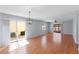 Open-concept living room with hardwood flooring, ceiling fan, and sliding glass doors to the patio at 1116 San Bernardo Rd, The Villages, FL 32162