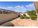 Rear patio bordered with garden beds and a low privacy wall at 1116 San Bernardo Rd, The Villages, FL 32162