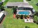Overhead shot features a screened-in pool, fire pit, and tropical landscaping at 11418 Lake Eustis Dr, Leesburg, FL 34788