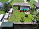 Aerial view of a backyard oasis featuring a pool, dock, boat lift, and spacious yard at 11418 Lake Eustis Dr, Leesburg, FL 34788