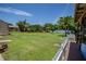 Expansive backyard with lush greenery, mature trees, dock, and waterfront access at 11418 Lake Eustis Dr, Leesburg, FL 34788