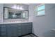Stylish bathroom with a double sink vanity, granite countertop, and a large mirror at 11418 Lake Eustis Dr, Leesburg, FL 34788