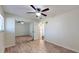 Bedroom with wood-look floors, ceiling fan, and mirrored closet at 11418 Lake Eustis Dr, Leesburg, FL 34788
