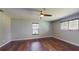 Spacious bedroom with wood floors, ceiling fan, and bright windows at 11418 Lake Eustis Dr, Leesburg, FL 34788