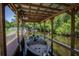 A boat dock with a boat, trees, and a canal at 11418 Lake Eustis Dr, Leesburg, FL 34788