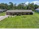 Aerial shot of the home showcasing the well-manicured lawn, brick exterior, and driveway at 11418 Lake Eustis Dr, Leesburg, FL 34788
