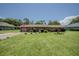 Charming brick home featuring a well-maintained lawn, an American flag, and a brick driveway at 11418 Lake Eustis Dr, Leesburg, FL 34788