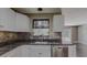 The kitchen area features white cabinets, granite countertops, stainless steel appliances, and sleek, modern backsplash at 11418 Lake Eustis Dr, Leesburg, FL 34788