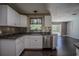 The kitchen area features white cabinets, granite countertops, stainless steel appliances, and sleek, modern backsplash at 11418 Lake Eustis Dr, Leesburg, FL 34788