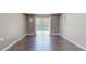 Spacious living room with hardwood floors and sliding glass doors to the pool at 11418 Lake Eustis Dr, Leesburg, FL 34788