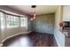 Open-concept living room with hardwood floors, bay windows, and stone accent wall at 11418 Lake Eustis Dr, Leesburg, FL 34788