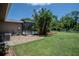 View of the screened-in pool area surrounded by well-maintained landscaping and a grassy lawn at 11418 Lake Eustis Dr, Leesburg, FL 34788