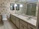 Bathroom featuring double sinks, floral wallpaper, and a shower at 11812 Watts Ct, Tavares, FL 32778